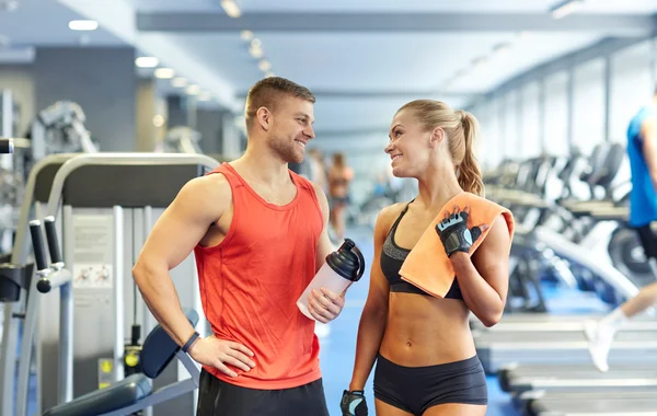 Glimlachende man en vrouw praten in de sportschool — Stockfoto