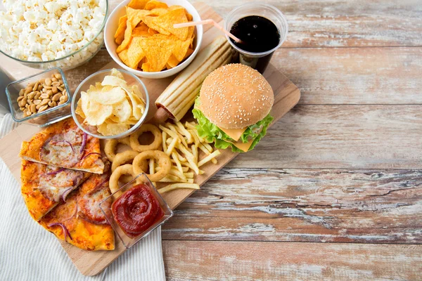 Close up of fast food snacks and drink on table — Stock Photo, Image