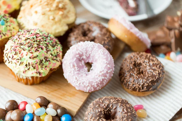 Close up of glazed donuts and sweets on table — Stock Fotó