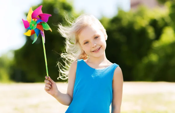 Happy little girl with colorful pinwheel at summer — Stock Photo, Image