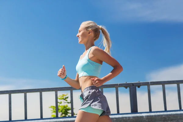 Sorridente giovane donna che corre all'aperto — Foto Stock