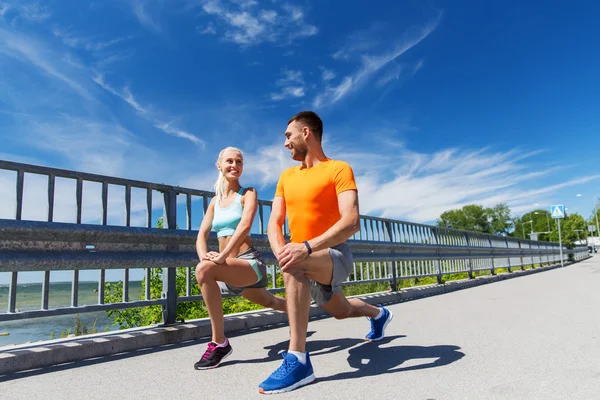 Sorridente coppia che si estende all'aperto — Foto Stock