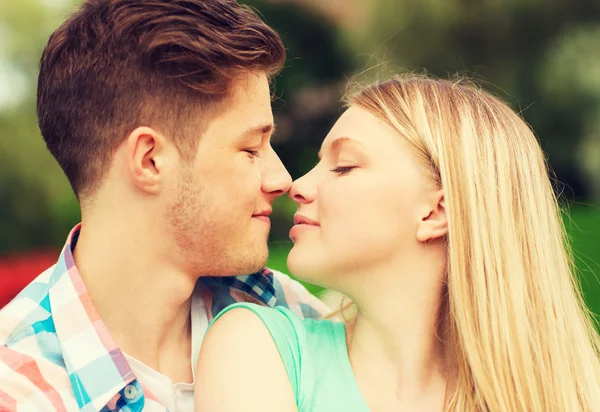 Smiling couple touching noses in park — Stock Photo, Image
