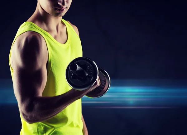 Close up of young man with dumbbell flexing biceps — Stock Photo, Image