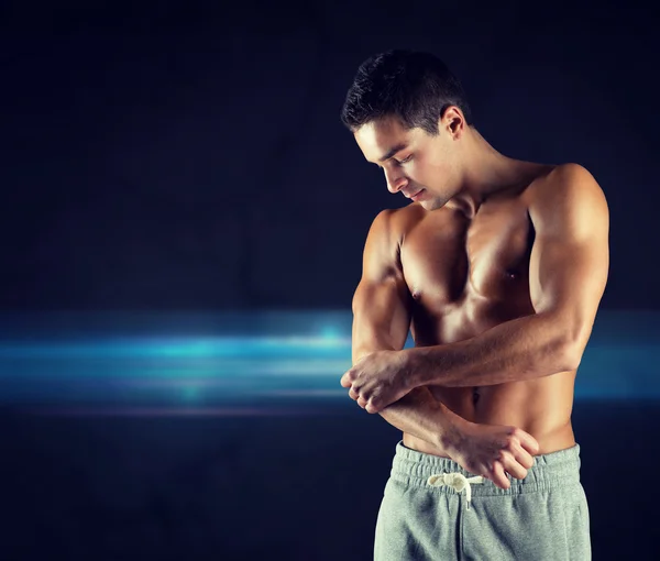 Joven culturista masculino lesionado tocando el codo — Foto de Stock