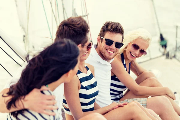 Amici sorridenti seduti sul ponte dello yacht — Foto Stock