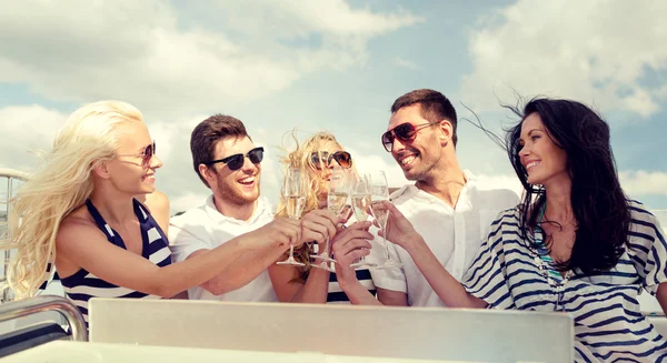 Lachende vrienden met glazen champagne op jacht — Stockfoto