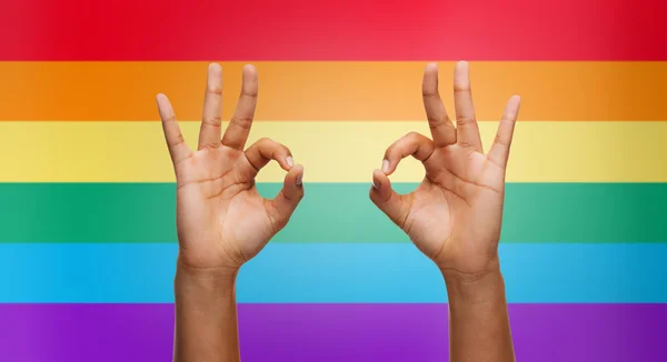 Hands showing ok sign over rainbow background — Stock Photo, Image
