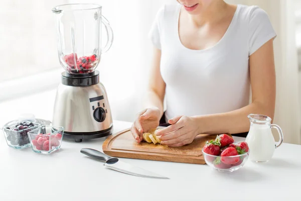 Close up of woman with blender chopping banana — ストック写真