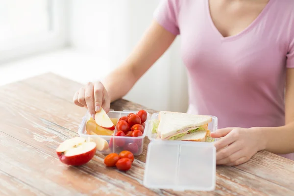 Close up of woman with food in plastic container — Stock Photo, Image