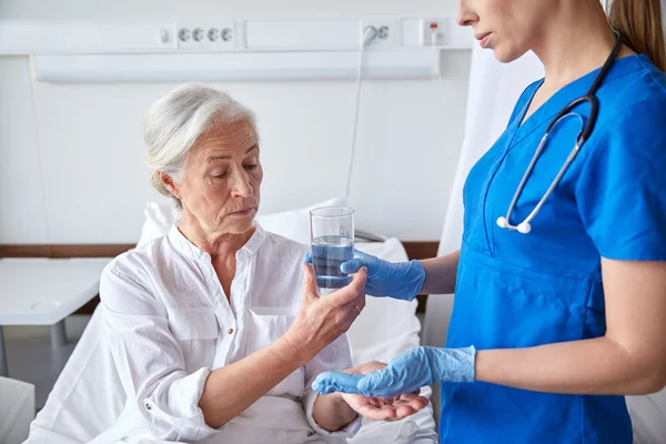 Infirmière donnant des médicaments à une femme âgée à l'hôpital — Photo