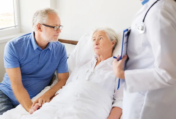Seniorin und Arzt mit Klemmbrett im Krankenhaus — Stockfoto