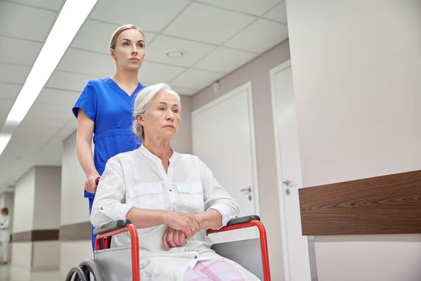 Enfermera con mujer mayor en silla de ruedas en el hospital —  Fotos de Stock