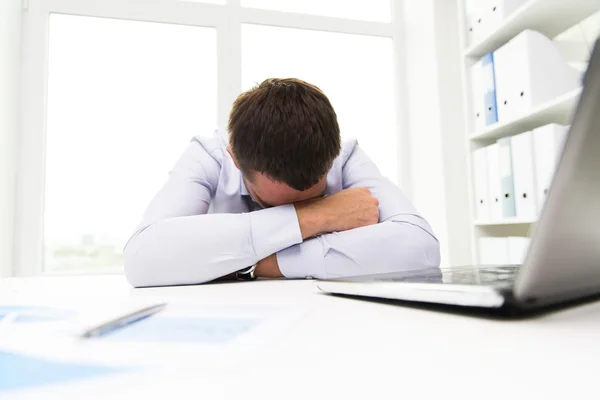 Geschäftsmann mit Laptop und Papieren im Büro — Stockfoto