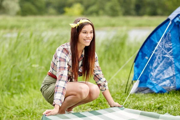 Feliz joven mujer que pone manta en el camping —  Fotos de Stock