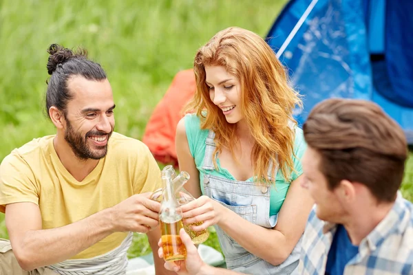 Amigos felices con tienda y bebidas en el camping — Foto de Stock