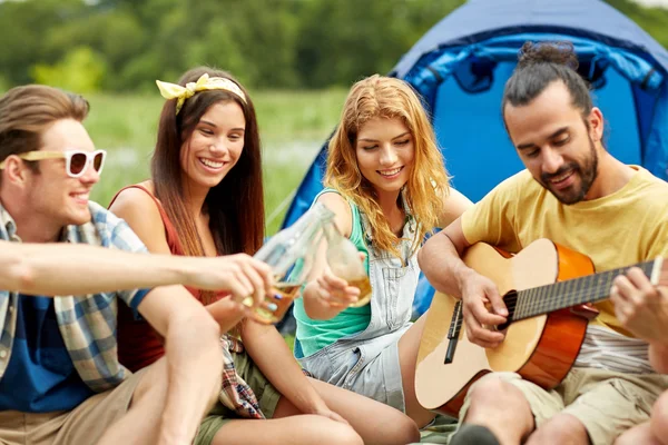 Amici felici con bevande e chitarra al campeggio — Foto Stock