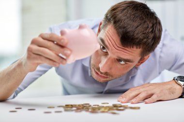 businessman with piggy bank and coins at office