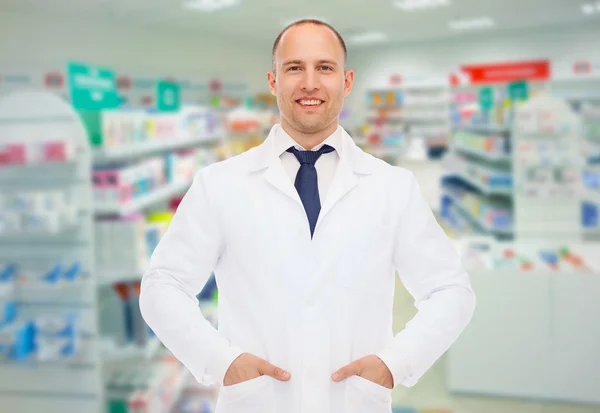 Glimlachend mannelijke apotheker in witte jas bij drogisterij — Stockfoto