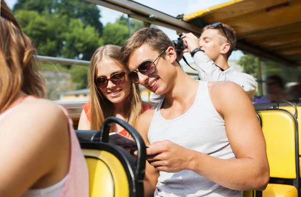 Happy couple with guidebook traveling by tour bus — Stok fotoğraf