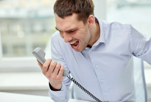 Woedend zakenman bellen op telefoon in kantoor — Stockfoto