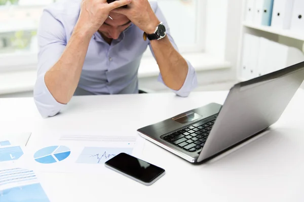 Zakenman met laptop en papers in office — Stockfoto