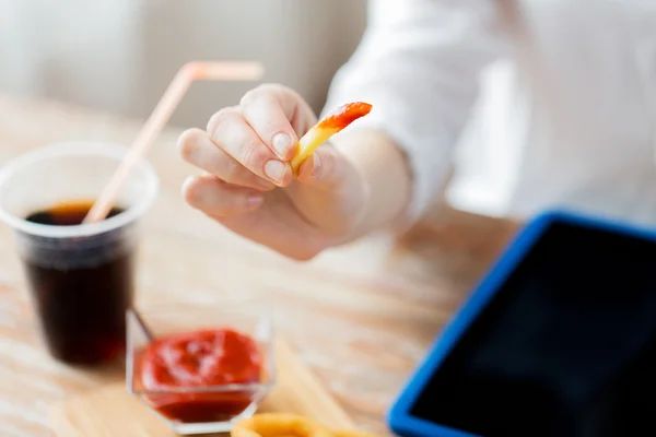 Close up of woman hand holding french fries — ストック写真