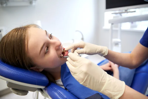 Dentista femenino chequeando dientes de niña paciente — Foto de Stock