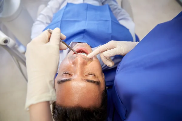 Gros plan du dentiste vérifiant les dents des patients masculins — Photo