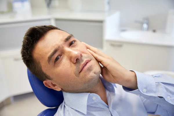 Man die kiespijn en zittend op dental stoel — Stockfoto