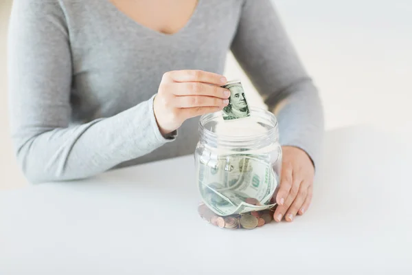 Крупним планом жіночі руки і доларові гроші в банці — стокове фото