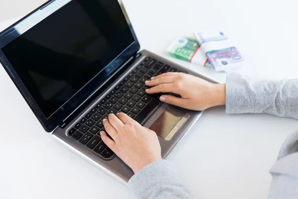 Close up of woman hands with laptop and money — Stock Photo, Image