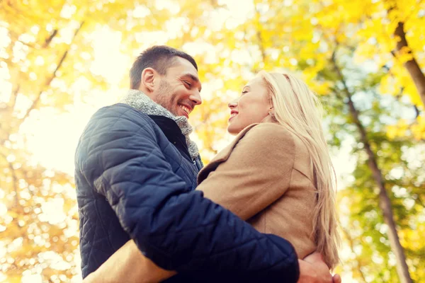 Couple souriant étreignant dans le parc d'automne — Photo