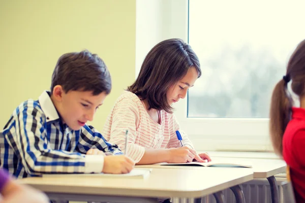 Groep van school-kids schrijven test in klas — Stockfoto