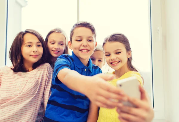 Grupo de escolares tomando selfie con smartphone —  Fotos de Stock