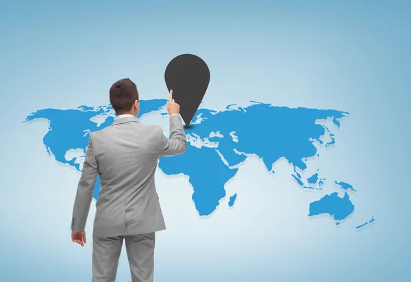 Бизнесмен указывает пальцем на карту мира — стоковое фото