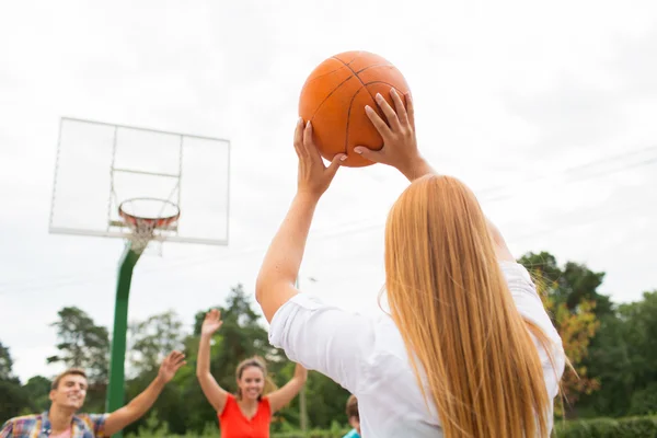 Groep gelukkig tieners spelen basketbal — Stockfoto