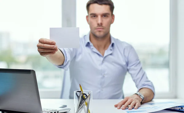 Hombre de negocios mostrando la tarjeta de papel en blanco en la oficina —  Fotos de Stock