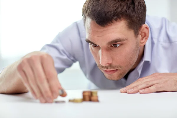 Businessman with coins at office — Stock Photo, Image