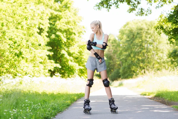 happy young woman in rollerblades riding outdoors