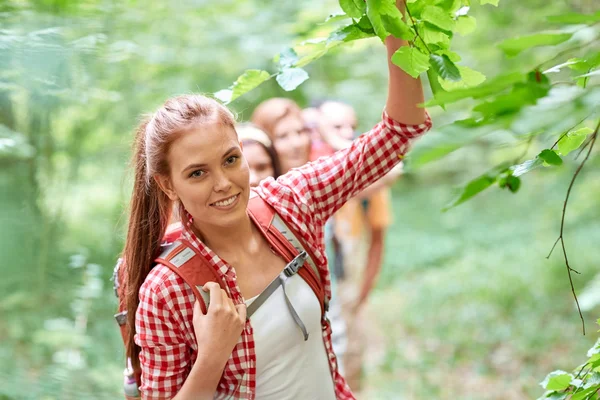 Grupp leende vänner med ryggsäckar vandring — Stockfoto