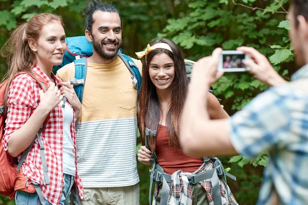 Friends with backpack photographing by smartphone — Stock Photo, Image