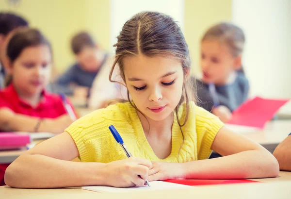 Group of school kids writing test in classroom Royalty Free Stock Images