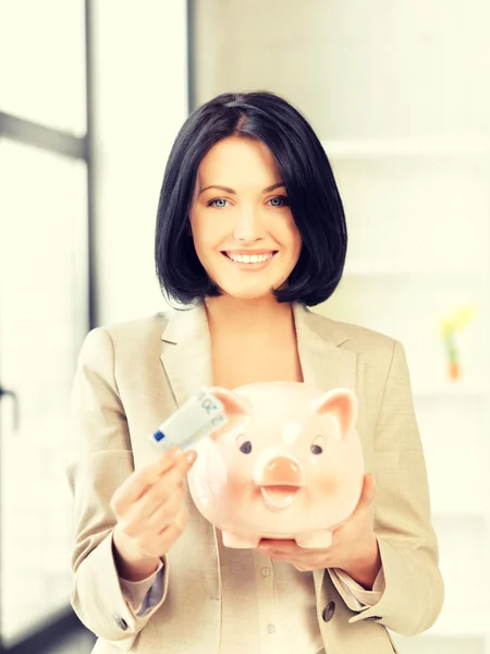 Schöne Frau mit Sparschwein und Geld — Stockfoto