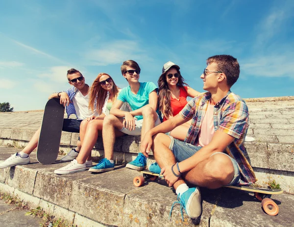 Skupina usmívající se přátel, sedí na ulici města — Stock fotografie