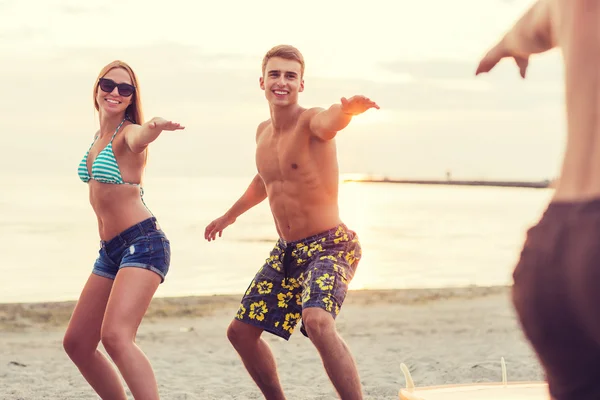 Amigos sorridentes em óculos de sol com surfes na praia — Fotografia de Stock