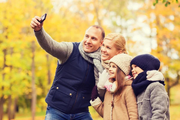 Happy family with camera in autumn park — Stock Photo, Image