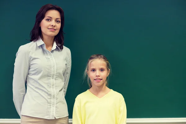 Menina da escola com professor em quadro-negro — Fotografia de Stock