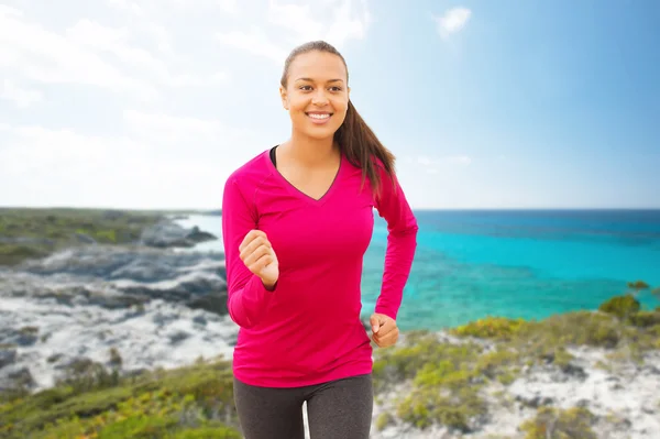 ผู้หญิงที่ยิ้มวิ่งบนชายหาด — ภาพถ่ายสต็อก
