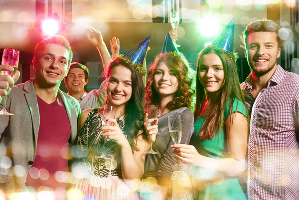 Smiling friends with glasses of champagne in club — Stock Photo, Image